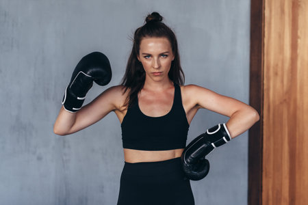 Female amateur boxer poses in boxing gloves.