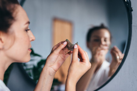 Young woman holds a patch in her hand before applying it to her skin