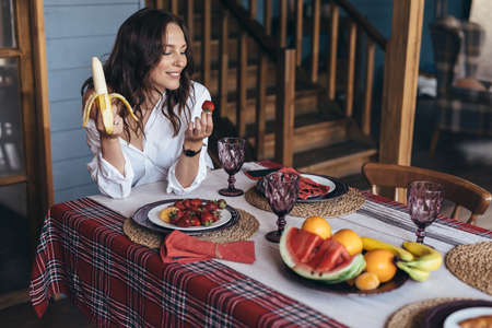 Young woman eating fruit in the kitchenの写真素材