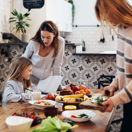 Preparing for family dinner, women are setting the table, while the girl is learning her lessons.