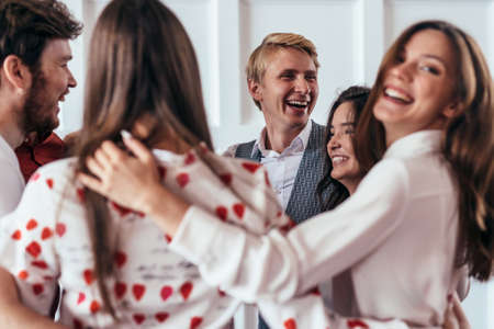 Circle of friends, funny young people hug and laughの写真素材