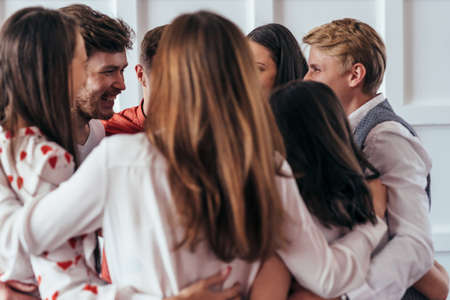 Group of friends are having fun, they are hugging closelyの写真素材