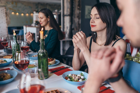 Group Of People Saying Prayers Before Meal.