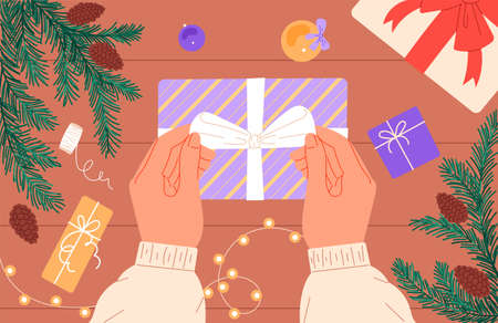 A person prepares a Christmas present, ties a ribbon bow on a boxのイラスト素材