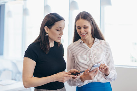 Two women with smartphones, using apps, looking at screens