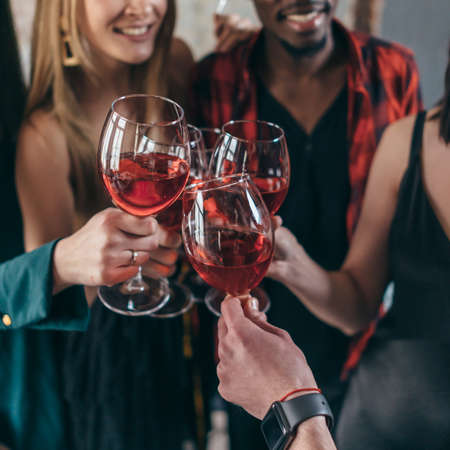 Friends drinking wine toasting while celebrating at restaurantの写真素材