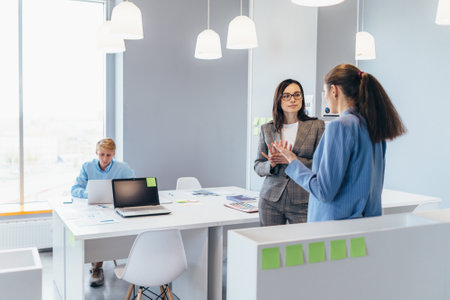 Business women standing in the office and talkingの写真素材