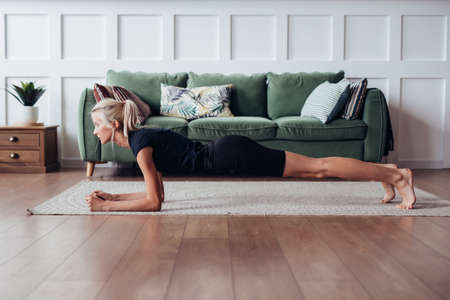 Young woman doing plank exercise at home.の写真素材