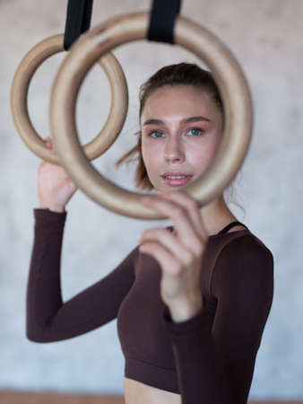 Fit woman with gymnastic rings at the gymの写真素材