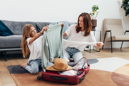 Mother and daughter going on trip pack suitcase