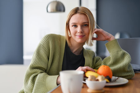 Portrait of a young woman at home in the kitchen
