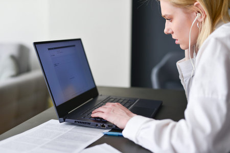 Woman looks intently at her laptop screen.