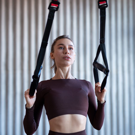 Fit woman training with fitness straps