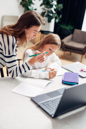 Woman helps a girl with her lessons