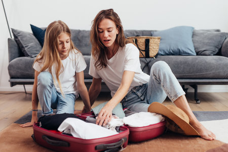 Mother and daughter going on trip pack suitcaseの写真素材
