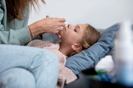 Mother Nasal Spraying Drugs for Sick Daughterの写真素材
