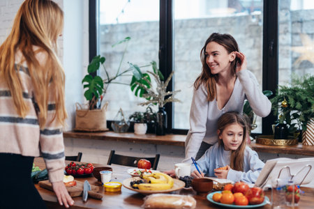 Young women set the table, girl does her homeworkの写真素材
