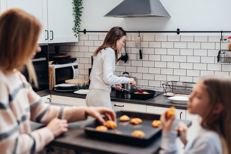 Young woman cooking pancakes in a frying panの写真素材