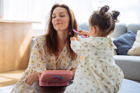Daughter brushes her mothers hairの写真素材