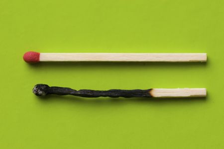 A burnt match and a live match lay side by side in harmonyの写真素材