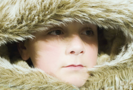 A boy wraps up warm with a fur-lined jacketの写真素材