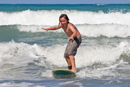 A young caucasian male learns to surf on Whangaehu Beach, Central Hawkes Bay, New Zealand