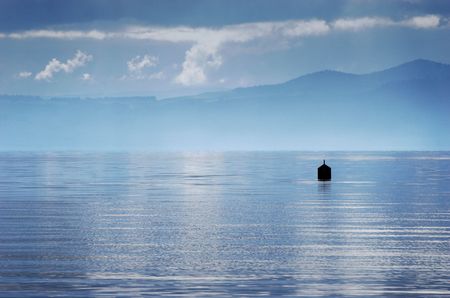 A buoy sits in Lake Taupo shrouded by stormy weather. Taupo, New Zealandの写真素材