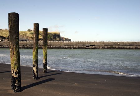 Poles at rivermouth at Patea, Taranaki, New Zealandの写真素材