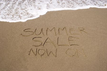 A summer sale written in the sandの写真素材