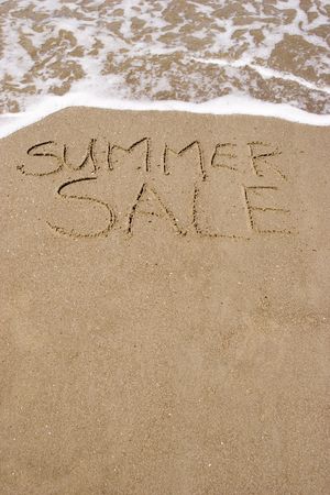 A summer sale written in the sandの写真素材