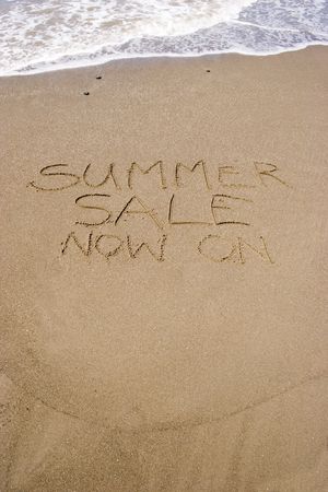 A summer sale written in the sandの写真素材