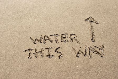 Water this way written in the sand at Haumoana Beach, Hawke's Bay, New Zealandの写真素材