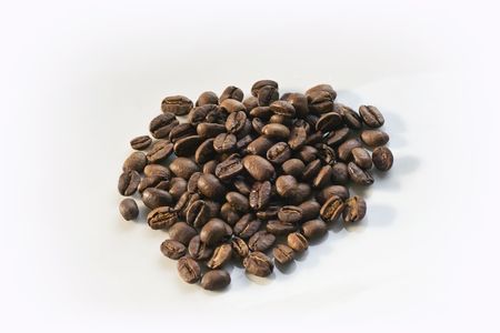 A pile of roasted coffee beans on white backgroundの写真素材