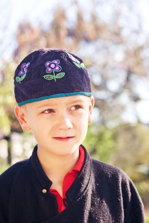 A young caucasian boy wearing a ethnic looking capの写真素材