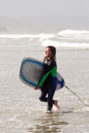 A young male exits the surf at Waimarama Beach, Hawkes Bay, New Zealandの写真素材