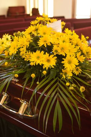 Flowers from the family on a casket at a funeral.の写真素材