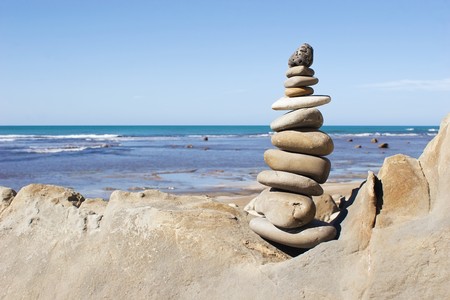 A stack of balanced stones with the beach in the background.の写真素材