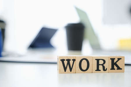 Text wooden cubes spelling is work on office tableの写真素材