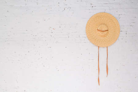 one hat hanging on the white wallの写真素材
