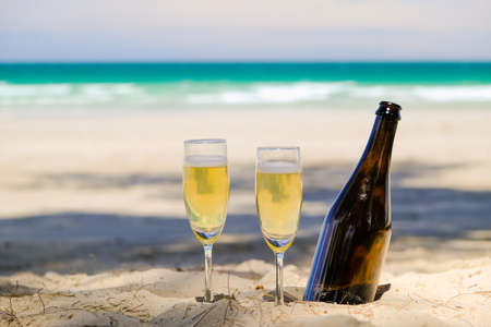 Two glasses of champagne on sand beachの写真素材