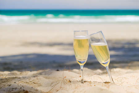 Two glasses of champagne on sand beachの写真素材