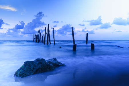 Old wooden bridge abandoned pier stumps at Thungsang bay in Chomphon province Thailand, Tropical beach seaside, White Balance effectの写真素材