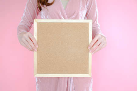 Portrait beautiful asian woman on pink background and wearing pink clothes with holding cork board, emotions action, fashion setの写真素材