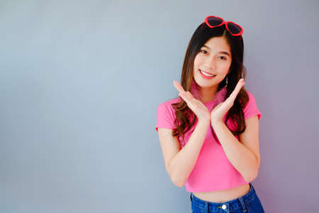 Portrait beautiful asian cheerful girl and beaming smile with fashion eyewear on gray background, emotions action, happy summer life conceptの写真素材