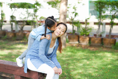 Happy asian family single mom and small daughter in the Parkの写真素材