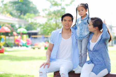 Happy asian family together with daughter in parkの写真素材