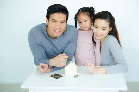 Asian family, father mother and daughter together saving moneyの写真素材