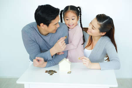 Asian family, father mother and daughter together saving moneyの写真素材