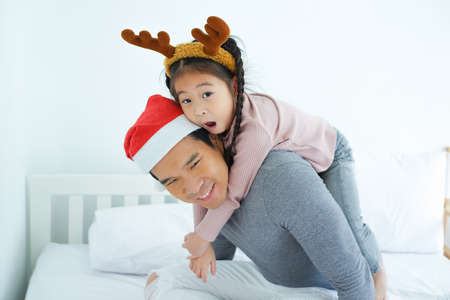 daughter riding on father's neck, holiday in festive Merry Christmas or Xmas and happy new year conceptの写真素材