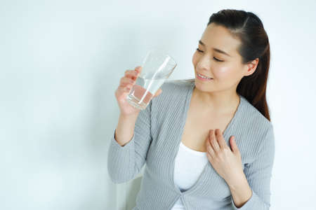 Asia woman drinking water on tableの写真素材